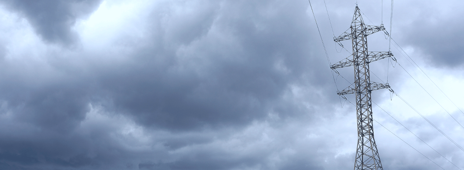 A power pole stands out against the heavily clouded sky. 
